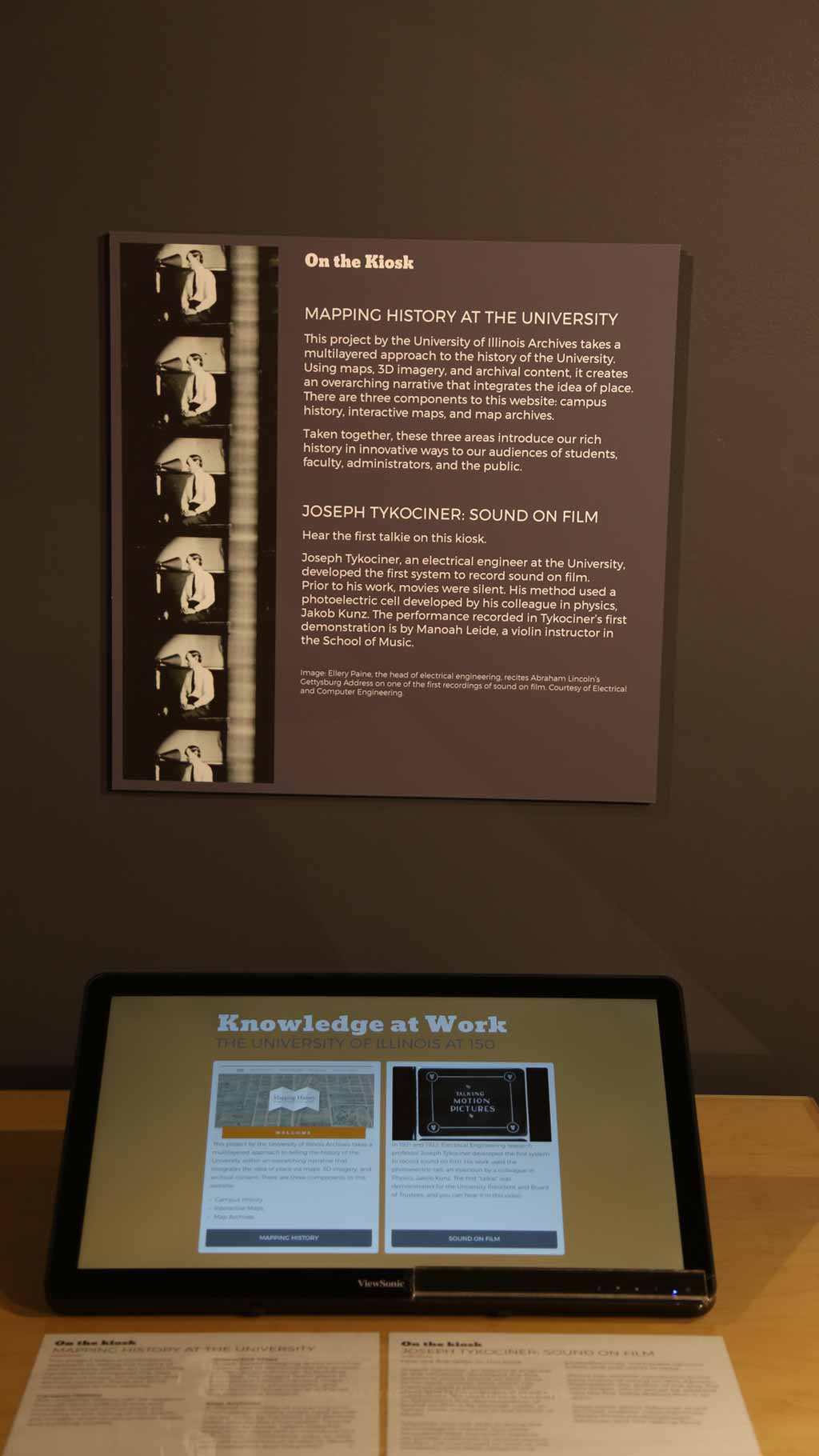 close-up of a part of the exhibit with an electronic device and a text panel about film, sound, and mapping