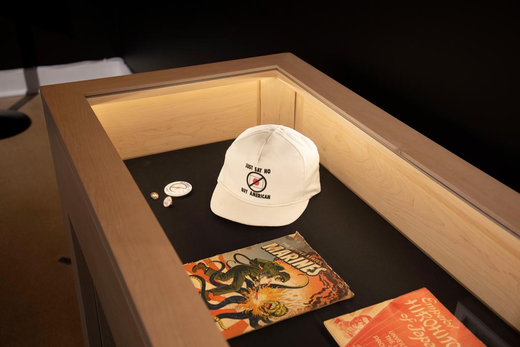 display case containing anti-japanese propaganda such as graphic novels and a hat