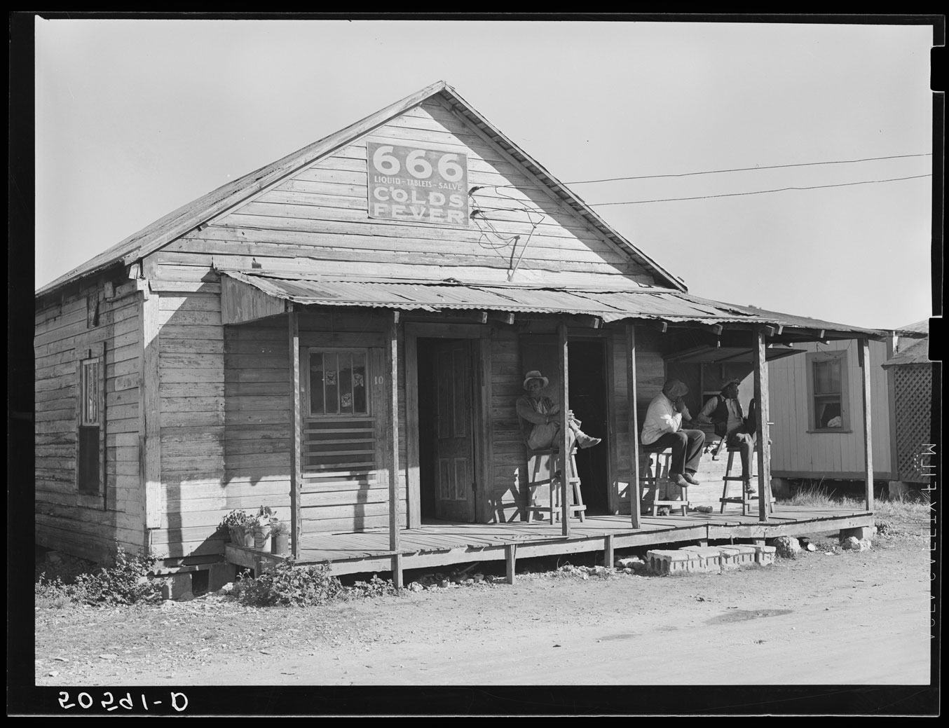 photograph of men sitting outside a juke joint