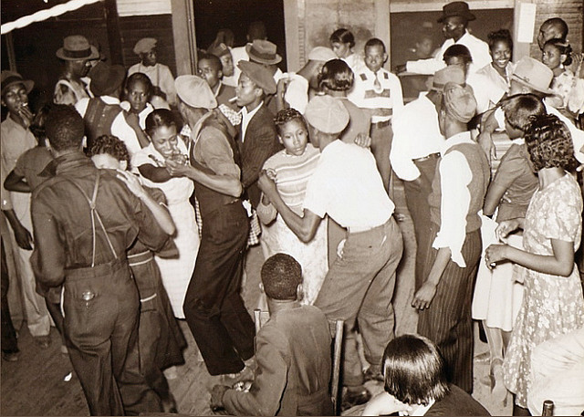 black and white photo of a room full of people dancing