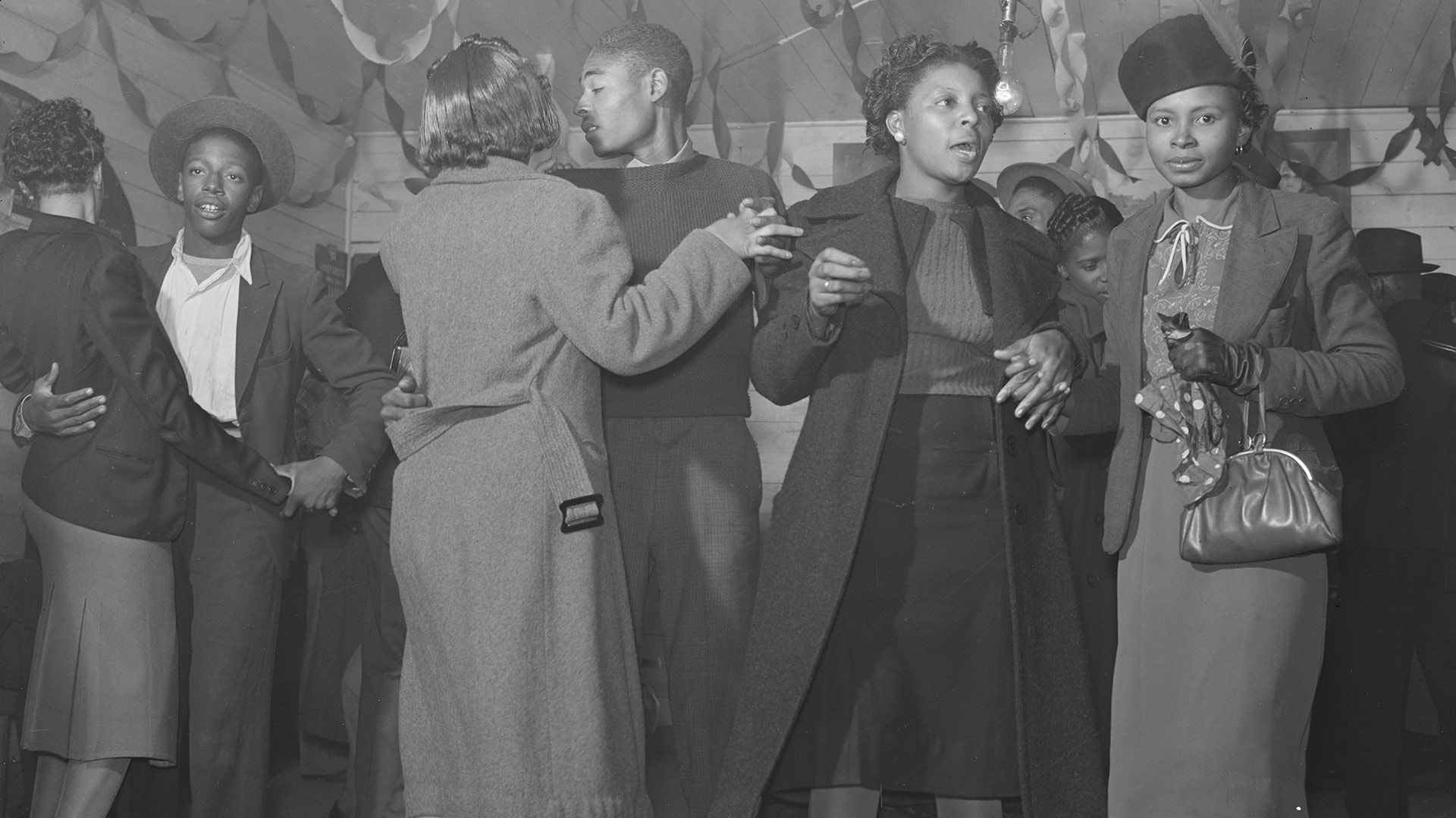 black and white photo of a group of people at a house party