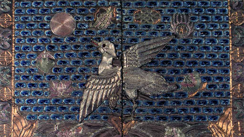 closeup photo of a mandarin textile square with embroidered bird