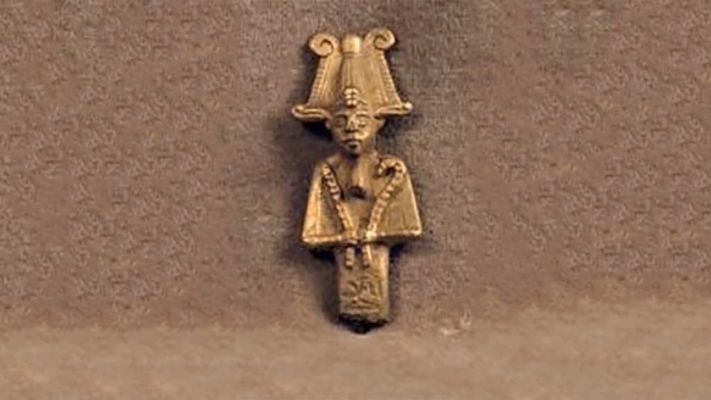 small golden figure with hat and two staffs
