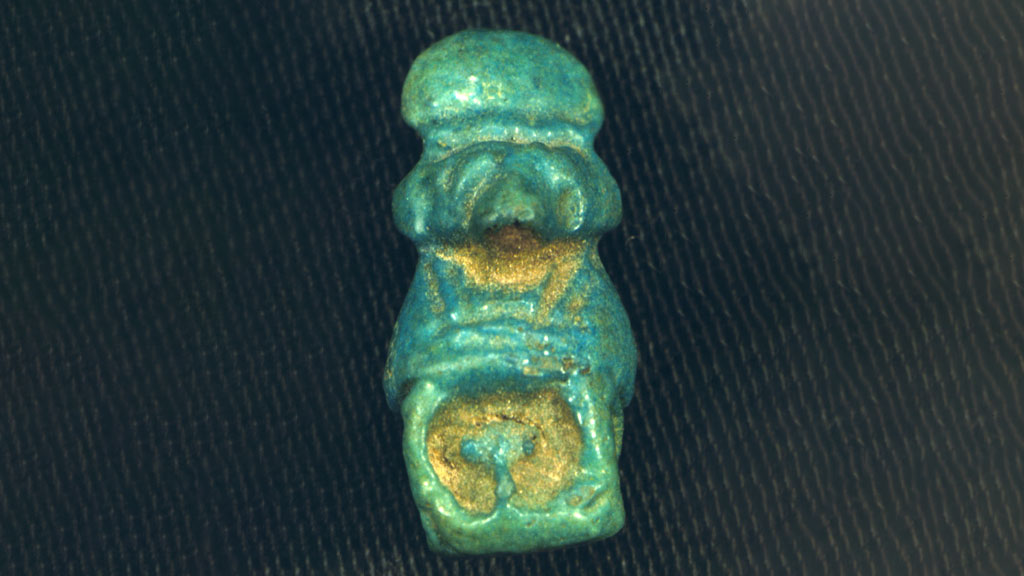 small shiny slightly humanoid green amulet