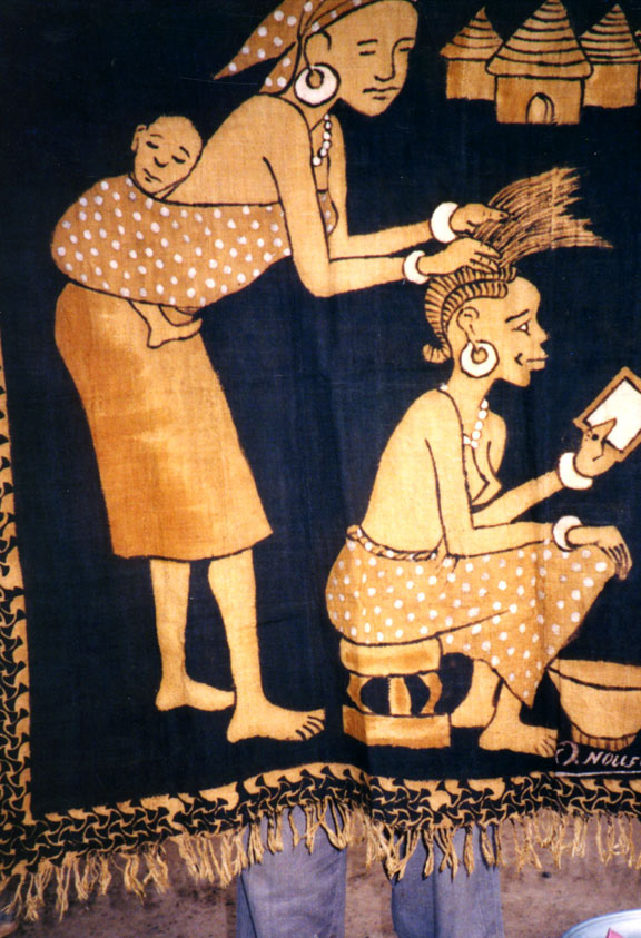 a mud cloth that depicts a woman braiding another woman's hair
