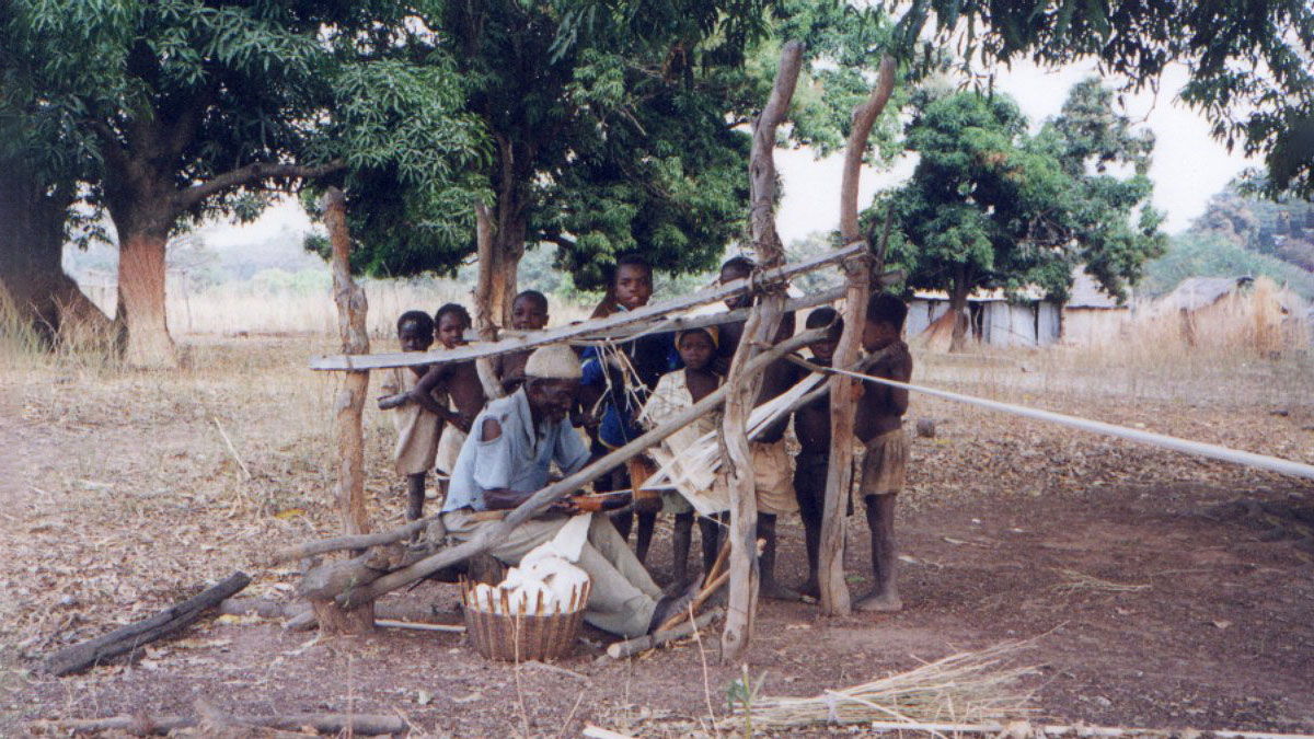 children watching a weaver weave