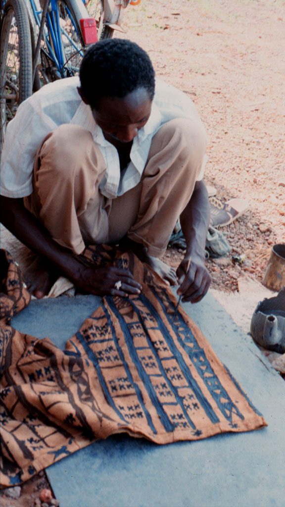 man painting a design on a pair of pants