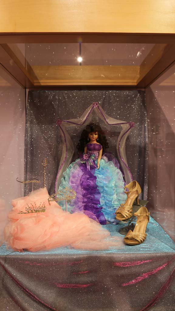 doll with blue dress and purple dress, three tiaras, and golden high heels