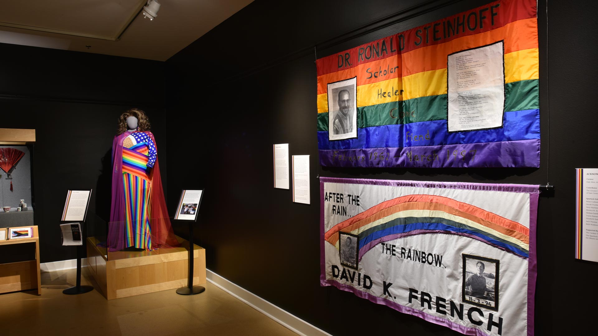 A far away shot of the exhibit showing the banners on the wall next to the display.
