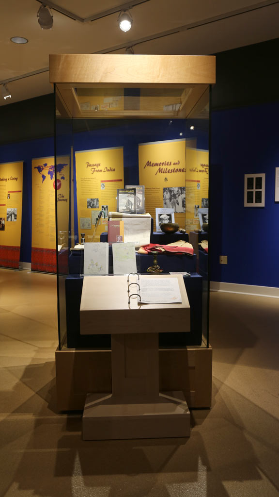 display case with various objects like papers, a book and a bowl