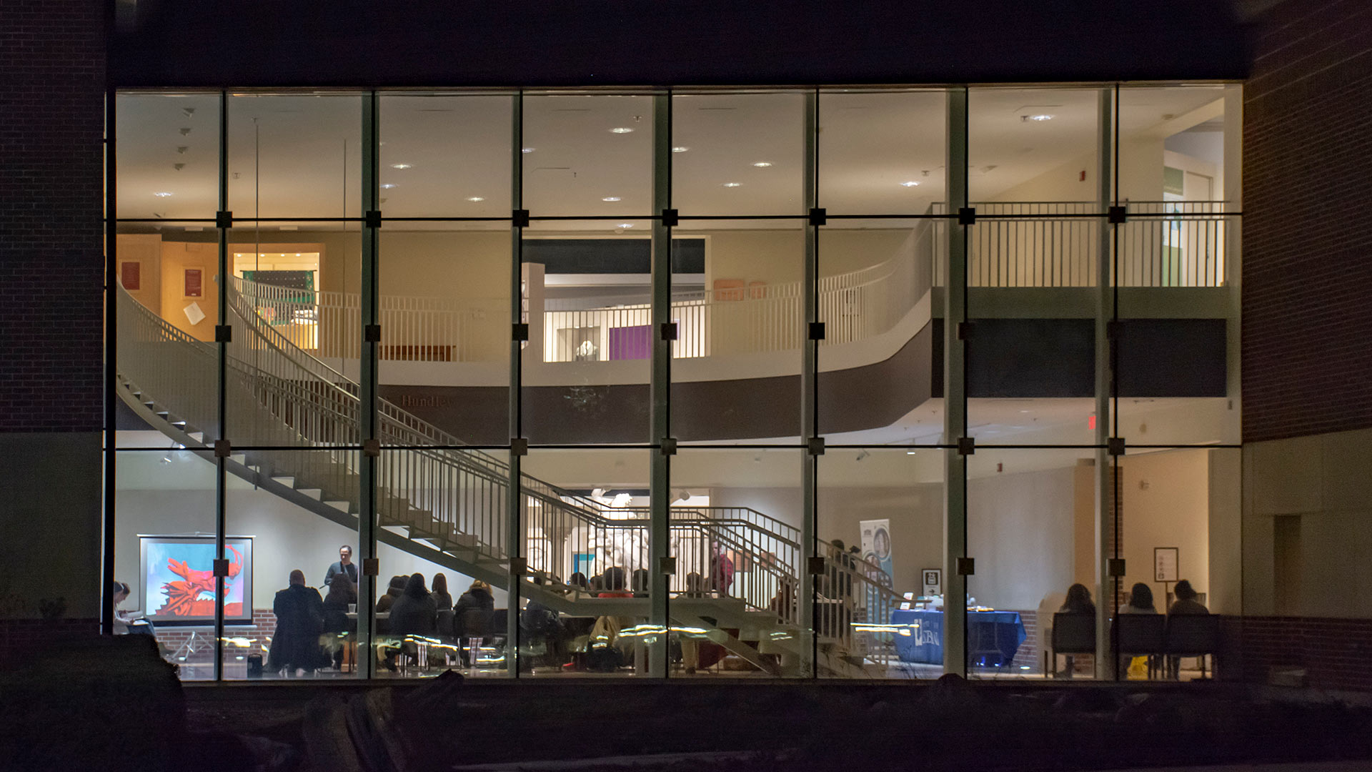 Outdoor night shot of building exterior with public program in progress